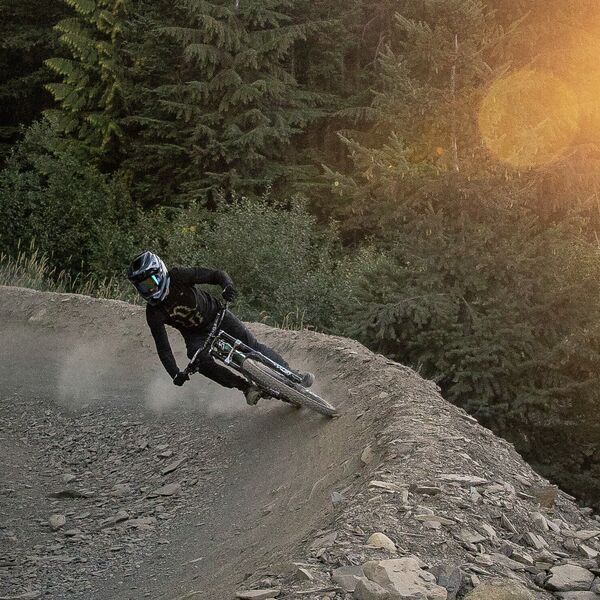 Biking around a berm in the Bike Park at sunset 