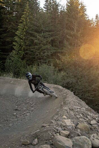 Biking around a berm in the Bike Park at sunset