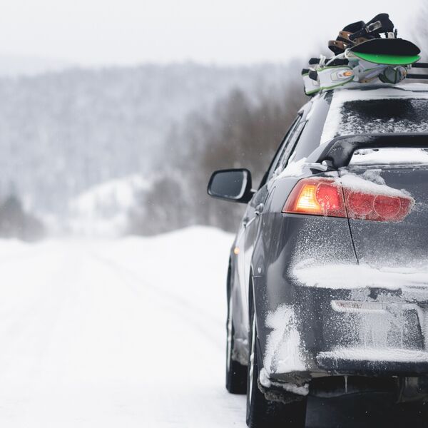 Snowboards on the roof of the car. Ski resort background.
